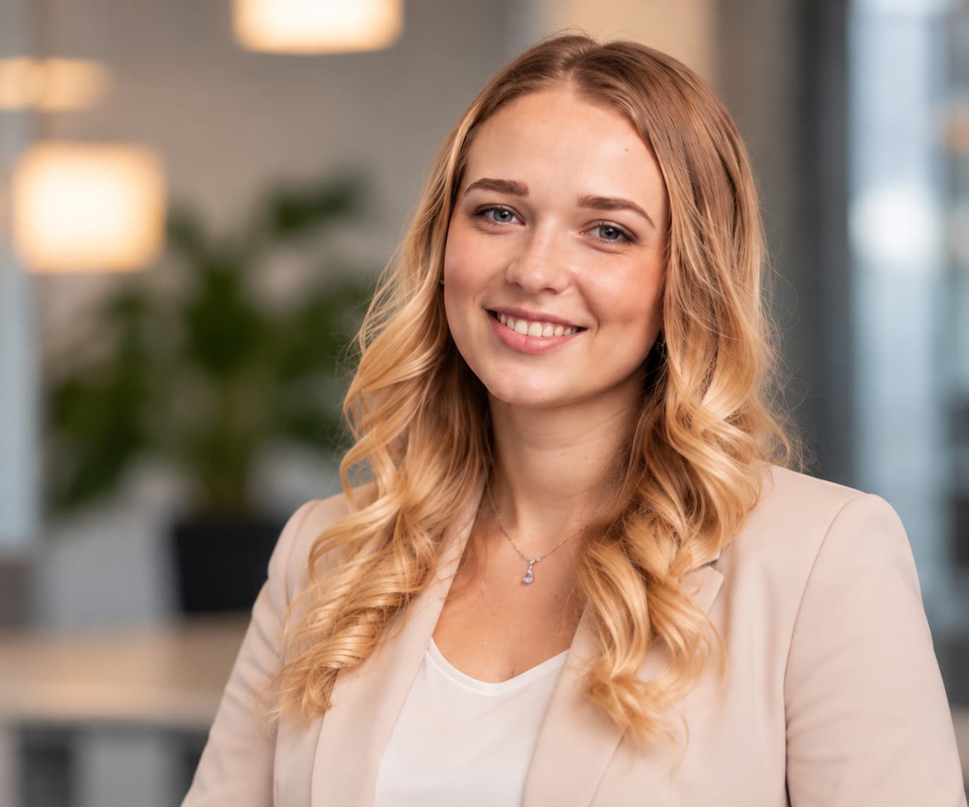 Dajana Wiebe lächelt in die Kamera, im hellen Büro mit Pflanze im Hintergrund